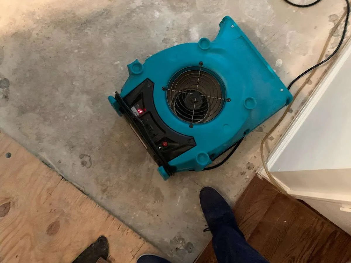 Air mover drying subfloor during Leak Detection & Repair in Burlington